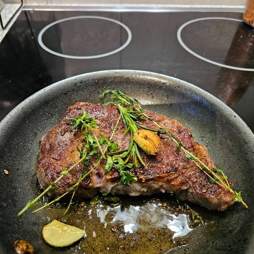 Steak basting in the pan with thyme and garlic