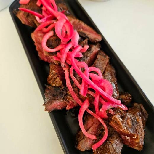 Sliced steak with pickled red onion